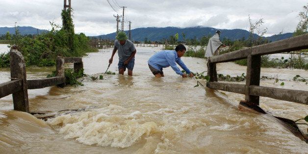 This picture from the Vietnam News Agency taken on October 11, 2017 shows men wading through a flooded area in the central province of Nghe An.At least 37 people have died and another 40 are missing after floods and landslides ravaged northern and central Vietnam, disaster officials said on October 12. / AFP PHOTO / Vietnam News Agency / VIETNAM NEWS AGENCY (Photo credit should read VIETNAM NEWS AGENCY/AFP/Getty Images)