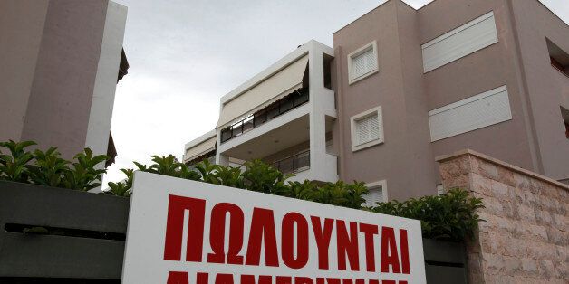 A sign advertises 'apartments for sale,' outside a new luxury housing development in the Glyka Nera suburb of Athens, Greece, on Sunday, Sept. 5, 2010. Greece still faces a 'substantial' default risk as insolvency prevents the nation from repaying its debt when its bailout program expires in three years. Photographer: Kostas Tsironis/Bloomberg via Getty Images