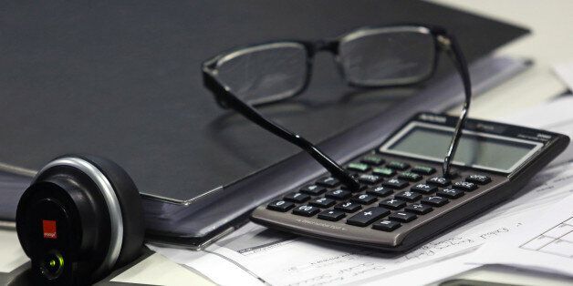 A fixed line telephone and a calculator sit next to a pair of spectacles on the trading floor at Panmure Gordon & Co. in London, U.K., on Friday, Jan. 22, 2016. At least 40 stock markets around the world with a total value of $27 trillion are in bear territory, as investors witness the worst start to a year on record. Photographer: Chris Ratcliffe/Bloomberg via Getty Images