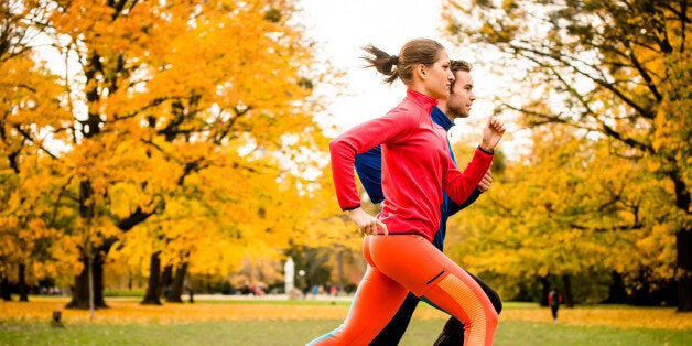 Young couple jogging together in park - rear view