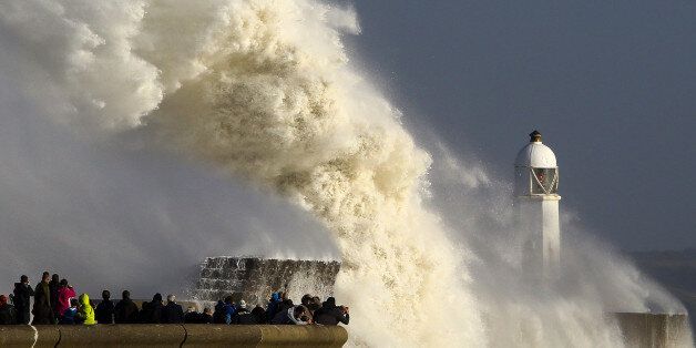 TOPSHOT - Huge waves strike the harbour wall and lighthouse at Porthcawl, south Wales, on October 16, 2017 as Storm Ophelia hits the UK and Ireland. Ireland was hit by an 'unprecedented storm' on Monday that left two people dead, 120,000 homes and businesses without power and closed every school in the country. The storm also sent strong winds over the southwest of England and the south and west of Wales. / AFP PHOTO / Geoff CADDICK (Photo credit should read GEOFF CADDICK/AFP/Getty Images)