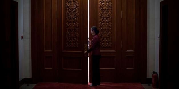 A hostess closes the door of a meeting room at the Great Hall of the People during the Communist Party's 19th Congress in Beijing on October 19, 2017.The Chinese Communist Party opens its week-long, twice-a-decade congress on October 18 at the Great Hall of the People. / AFP PHOTO / FRED DUFOUR (Photo credit should read FRED DUFOUR/AFP/Getty Images)