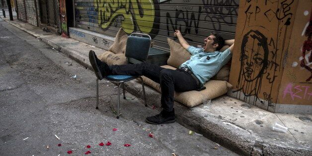 A man yawns while resting on a street in Athens, Greece June 28, 2015. Greece's European partners shut the door on extending a credit lifeline to Athens, leaving the country facing a default that could push it out of the euro and cause ripple effects across the European economy and beyond. REUTERS/Marko Djurica