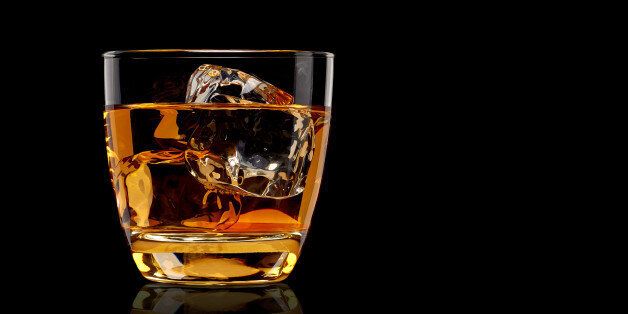Whiskey in glass on black background
