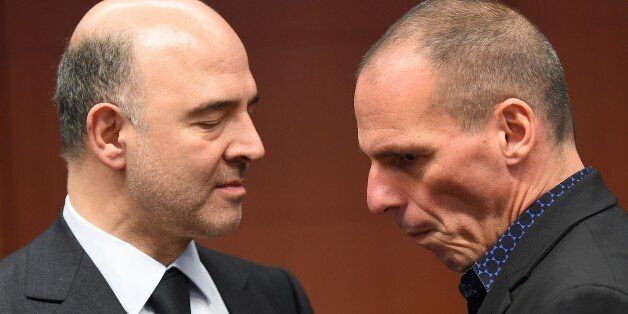 Greece's Finance Minister Yanis Varoufakis (R) speaks with European Commissioner for Economic and Financial Affairs, Taxation and Customs Pierre Moscovici during a Eurogroup finance ministers meeting at the European Council in Brussels, March 9, 2015. AFP PHOTO / EMMANUEL DUNAND (Photo credit should read EMMANUEL DUNAND/AFP/Getty Images)