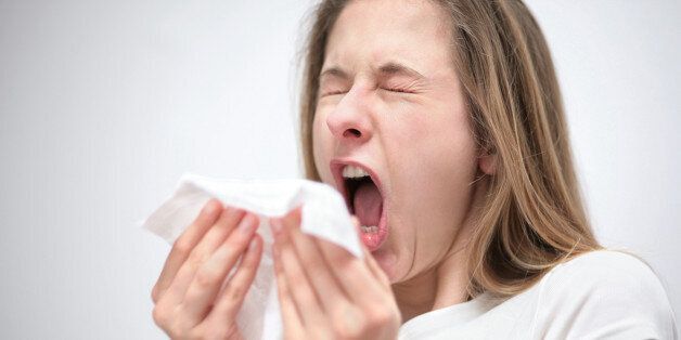 portrait of a young woman with tissue sneezing