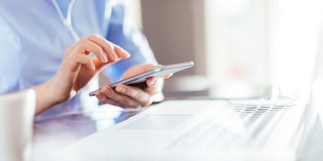 Businesswoman typing on smart phone