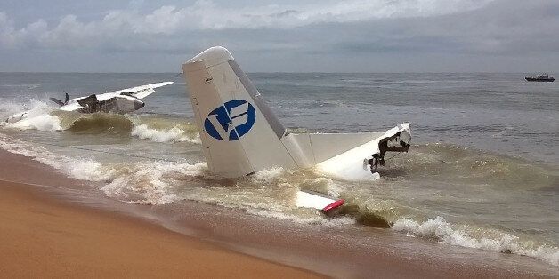 A picture taken on October 14, 2017 with a mobile phone shows the wreckage of a plane that crashed off Ivory Coast today, killing at least four people. The aircraft had been chartered by the French army as part of the anti-jihadist Operation Barkhane, a French military source told. Four Moldavians were killed and six other people, including French nationals, injured in the crash of the Antonov aircraft which had 10 people on board, the source said. / AFP PHOTO / Sia KAMBOU (Photo credit s