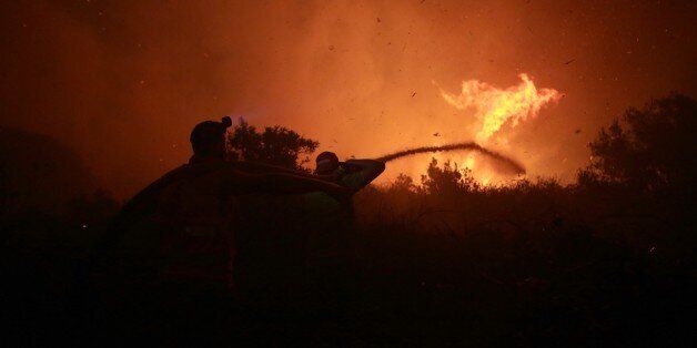 LISBON, PORTUGAL - OCTOBER 16: Firefighters try to extinguish amid forest fire in Serra de Bouro district of Leiria, north of Lisbon, Portugal on October 16, 2017. There were registered over 500 fires resulting on, until now, 27 dead, have broken out in all over the country. (Photo by Joao Henriques/Anadolu Agency/Getty Images)