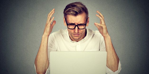 Stressed man working on computer. Negative human emotion face expression .
