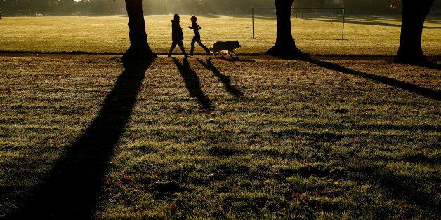 A woman runs past a dog walker in Victoria Park in Leicester, Britain September 22, 2017. REUTERS/Darren Staples