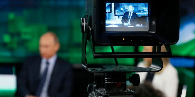 Russia's President Vladimir Putin visits the new studio complex of the state-owned English-language Russia Today television network in Moscow, on June 11, 2013. AFP PHOTO/ POOL/ YURI KOCHETKOV (Photo credit should read YURI KOCHETKOV/AFP/Getty Images)