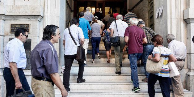 ATHENS, GREECE - JULY 20: A National Bank official opens the door of a bank branch as people enter after Greek banks reopened on Monday morning after three weeks of closure on July 20, 2015 in Athens, Greece. Many restrictions on transactions will remain and a lot of goods and services will become more expensive as a result of a rise in value added tax (VAT) approved by Parliament last Thursday, which is among the first batch of austerity measures demanded by Greece's creditors. (Photo by Milos Bicanski/Getty Images)