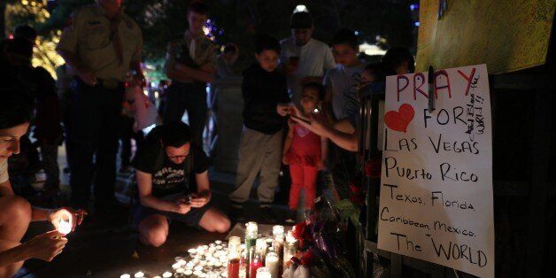 LAS VEGAS, USA - OCTOBER 3: People light candles and leave flowers during memorial for Las Vegas mass shooting victims, who lost their lives after a gunman attack in Las Vegas, NV, United States on October 3, 2017. At least 59 people were killed and more than 527 others wounded at a country music concert in the city of Las Vegas late Sunday night in the mass shooting. A gunman -- identified as Stephen Paddock -- opened fire on more than 10,000 concert-goers at an outdoor venue from across the Mandalay Bay Hotel at around 10.08 p.m. local time (0508GMT Monday), Clark County Sheriff Joseph Lambardo from the Las Vegas Metropolitan Police Department (LVMPD) told reporters. (Photo by Bilgin Sasmaz/Anadolu Agency/Getty Images)