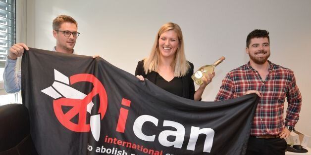 (From L) Nuclear disarmament group ICAN coordinator Daniel Hogstan, executive director Beatrice Fihn and her husband Will Fihn Ramsay pose with a banner bearing the group's logo after ICAN won the Nobel Peace Prize for its decade-long campaign to rid the world of the atomic bomb as nuclear-fuelled crises swirl over North Korea and Iran, on October 6, 2017 in Geneva.With the nuclear threat at its most acute in decades, the International Campaign to Abolish Nuclear Weapons, which on October 6 won the Nobel Peace Prize, is urgently pressing to consign the bomb to history. / AFP PHOTO / Fabrice COFFRINI (Photo credit should read FABRICE COFFRINI/AFP/Getty Images)