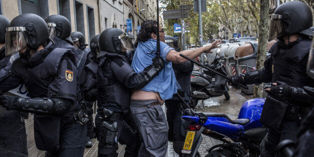Spanish riot police hold batons as they manhandle a voter in the Sant Antoni district of Barcelona, Spain, on Sunday, Oct. 1, 2017. Spanish police moved in to shut down some polling stations as voting began Sunday in Catalonia's illegal referendum on independence. Photographer: Angel Garcia/Bloomberg via Getty Images