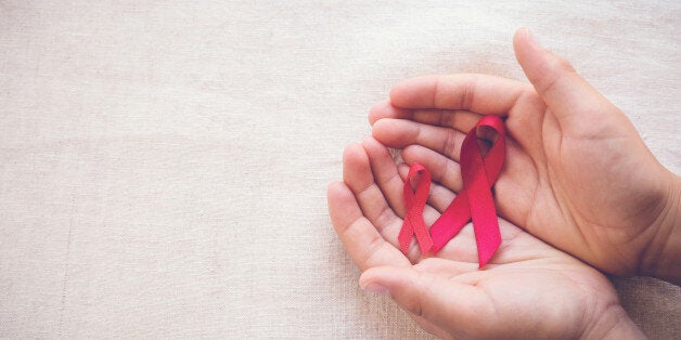 hands holding Red Ribbons on toning background, HIV/AIDS, Anosmia, Heart disease,Epidermolysis bullosa and Vasculitis awareness