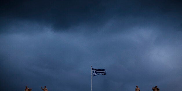 The Greek flag flutters on the Archeological Museum in Central Athens. December 23, 2016. (Photo by Kostis Ntantamis/NurPhoto via Getty Images)