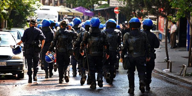 Istanbul, Turkey - 1 May 2008: Police officers in full riot gear face protesters during the May Day demonstration in istanbul, Turkey, on May 1, 2008.'