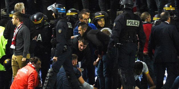 French police officers and members of the stadium staff gather to help LOSC's supporters following the fall of their tribune during the French L1 football match between Amiens and Lille LOSC on September 30, 2017 at the Licorne stadium in Amiens.Several Lille supporters were hurt in Amiens when a stadium barrier collapsed in the away section as the visiting fans celebrated the opening goal of the match. The Ligue 1 fixture was interrupted in the 16th minute after Fode Ballo-Toure's goal sparked celebrations that caused a fence separating the fans from the pitch to crumble under their weight. Dozens of fans tumbled down on to the side of the pitch, crushed by fellow supporters, with medical staff quickly rushing to the scene to tend to those injured. / AFP PHOTO / FRANCOIS LO PRESTI (Photo credit should read FRANCOIS LO PRESTI/AFP/Getty Images)