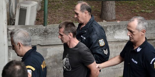 Russian Alexander Vinnik (C) is escorted by police officers as he arrives at a courthouse in Thessaloniki on September 29, 2017. Alexander Vinnik, who headed BTC-e, an exchange he operated for the Bitcoin crypto-currency, was indicted by a US court in late July on 21 charges ranging from identity theft and facilitating drug trafficking to money laundering. Moscow has requested the extradition of Russian national also wanted in the United States for laundering billions of dollars through a Bitcoin exchange he operated. / AFP PHOTO / SAKIS MITROLIDIS (Photo credit should read SAKIS MITROLIDIS/AFP/Getty Images)