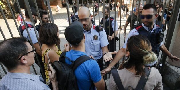 Catalan police officers 'Mossos d'Esquadra' try stop pro-referendum people from going into 'Escola Collaso i Gil' school on September 29, 2017 in Barcelona.Pro-separatist Catalans occupied several schools in Barcelona today which are designated to be polling stations in a contested independence referendum to ensure the vote will go ahead, according to AFP reporters at the scene. / AFP PHOTO / PAU BARRENA (Photo credit should read PAU BARRENA/AFP/Getty Images)