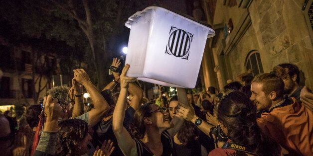 BARCELONA, SPAIN - OCTOBER 01: An election official carries an empty polling box out of the polling station after the counting had finished for the referendum vote on October 1, 2017 in Barcelona, Spain. More than five million eligible Catalan voters are estimated to visit 2,315 polling stations today for Catalonia's referendum on independence from Spain. The Spanish government in Madrid has declared the vote illegal and undemocratic. (Photo by Dan Kitwood/Getty Images)
