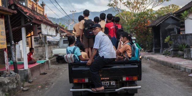 Student evacuated from their home due to the volcanic activities of Mount Agung, on a car as they head of school in a temporary shelter in in Karangasem regency, Bali, Indonesia, on September 29, 2017. Seismic activity below Mount Agung has been growing over recent weeks, with hundreds of tremors every day. Over the weekend, a plume of smoke has been seen rising from the crater. More than 134.000 people have fled the area around the crater and the alert was raised to the highest level on 22nd of September. (Photo by Agoes Rudianto/NurPhoto via Getty Images)