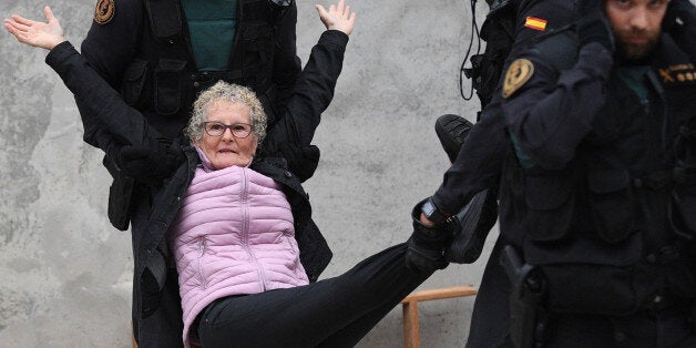 SANT JULI, SPAIN - OCTOBER 01: An elderly woman is removed by force as police move in on the crowds as members of the public gather outside to prevent them from stopping the opening and intended voting in the referendum at a polling station where the Catalonia President Carles Puigdemont will vote later today on October 1, 2017 in Sant Julia de Ramis, Spain. More than five million eligible Catalan voters are estimated to visit 2,315 polling stations today for Catalonia's referendum on independence from Spain. The Spanish government in Madrid has declared the vote illegal and undemocratic. (Photo by David Ramos/Getty Images)