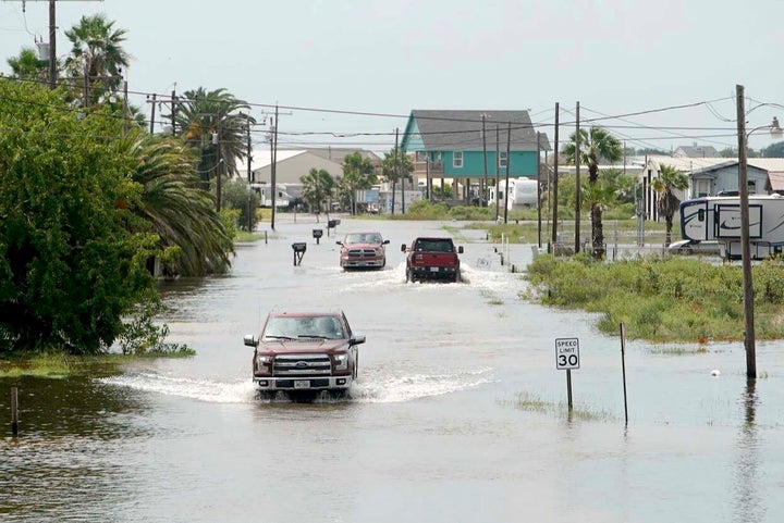 Trucks drive down Carancahua Street to enter neighborhoods in Sargent, Texas, Wednesday, Sept. 18, 2019. Imelda has deluged parts of Southeast Texas with nearly 20 inches of rain.