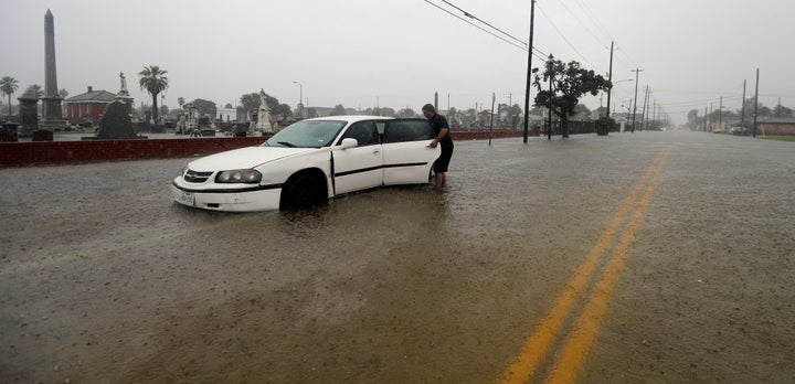 Angel Marshman opens the back door to his flooded car as he stands in floodwaters from Tropical Depression Imelda Wednesday, Sept. 18, 2019, in Galveston, Texas.