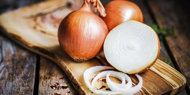 Golden onions on rustic wooden background