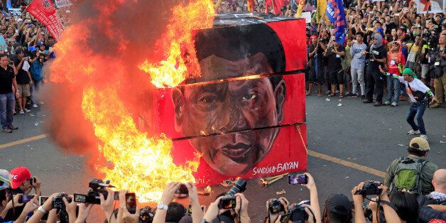 Protesters burn a cube effigy with a face of President Rodrigo Duterte during a National Day of Protest outside the presidential palace in metro Manila, Philippines September 21, 2017. REUTERS/Romeo Ranoco TPX IMAGES OF THE DAY