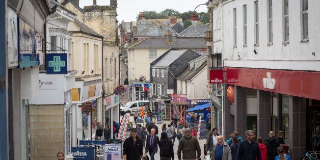 REDRUTH, UNITED KINGDOM - JULY 26: People walk along the main street in Redruth on July 26, 2017 in Cornwall, England. Figures released by Eurostat in 2014 named the British county of Cornwall as one of Europe's top ten poverty areas falling behind Poland, Lithuania and Hungary. Average wages were Â£14,300 compared with the UK national figure of Â£23,300 and Â£20,750 across Europe. UK government statistics show almost a quarter of people living in the Camborne, Pool and Redruth (CPR) area of Cornwall are in one of the most deprived areas of England with the highest level of childhood obesity, almost a quarter of children aged under 16 living in poverty and the lowest life expectancy. The area, which has long suffered from severe industrial decline with the demise of the copper and tin mining industries, has not shared in the wealth created in nearby tourist havens such as Newquay, Padstow and St Ives. Cornwall is the only UK county to have previously received emergency funding from the European Union (EU) and was one of the major beneficiaries of the UK's membership of the EU due to the large amount of funding made available through the EUs Objective One and Convergence programmes. Despite this voters overwhelmingly backed the campaign to leave the European Union in the June 2016 referendum. (Photo by Matt Cardy/Getty Images)