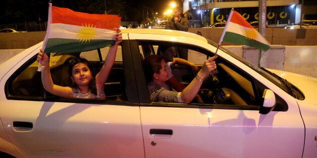 SULAYMANIYAH, IRAQ - 2017/09/25: A Kurdish family is seen inside their car while holding Kurdish flags and celebrating the referendum during the night. September 25, 2017 is a historic day for Kurdish people around the world as many Kurdish took part in a landmark vote on independence for Iraq's Kurdistan region. Votes are currently still being counted, with an expected victory for YES. The referendum runned off quietly in the three provinces that make up the region, and in places controlled by Kurdish forces. The Kurdish Rudaw website published recently that more than 90% have voted for independence. (Photo by Rahman Hassani/SOPA Images/LightRocket via Getty Images)