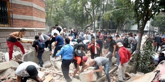 People remove debris of a damaged building after a real quake rattled Mexico City on September 19, 2017 while an earthquake drill was being held in the capital.A powerful earthquake shook Mexico City on Tuesday, causing panic among the megalopolis' 20 million inhabitants on the 32nd anniversary of a devastating 1985 quake. The US Geological Survey put the quake's magnitude at 7.1 while Mexico's Seismological Institute said it measured 6.8 on its scale. The institute said the quake's epicenter wa