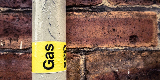 Detail Of A Residential Gas Pipe Against A Red Brick Wall