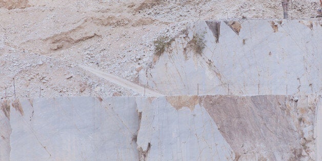 CARRARA, ITALY - AUGUST 23: Workers use excavators and diamond-cutting cables to cut 20t white marble blocks in the Michelangelo Marble Quarries in the Apuan Alps on August 23, 2017 in Carrara, Italy. Carrara marble has been used since the time of Ancient Rome in the construction of some of Antiquity's most magnificent monuments, including the Pantheon and Trajan's Column. It was also used in the construction of Marble Arch in London. Michelangelo used Carrara marble for his Pieta statue. Centuries of quarrying have created a distinctive landscape making the mountains appear to be covered in snow, even during the summer. (Photo by Michele Tantussi/Getty Images)