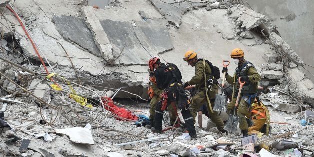 Rescuers from Israel take part in the search for survivors in a flattened building in Mexico City on September 21, 2017 two days after a strong quake hit central Mexico.A powerful 7.1 earthquake shook Mexico City on Tuesday, causing panic among the megalopolis' 20 million inhabitants on the 32nd anniversary of a devastating 1985 quake. / AFP PHOTO / Yuri CORTEZ (Photo credit should read YURI CORTEZ/AFP/Getty Images)