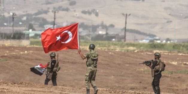 Soldiers holding Turkish and Iraqi flags walk during a joint military exercise near the Turkish-Iraqi border in Sirnak in Silopi district on September 26, 2017. Turkey launched a military drill with tanks close to the Iraqi border the army said, a week before Iraq's Kurdish region will hold an independence referendum on September 25. / AFP PHOTO / ILYAS AKENGIN (Photo credit should read ILYAS AKENGIN/AFP/Getty Images)