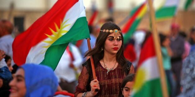 Syrian Kurds wave the Kurdish flag in celebration, in the northeastern Syrian city of Qamishli on September 26, 2017, in support of the independence referendum in Iraq's autonomous northern Kurdish region. / AFP PHOTO / Delil souleiman (Photo credit should read DELIL SOULEIMAN/AFP/Getty Images)