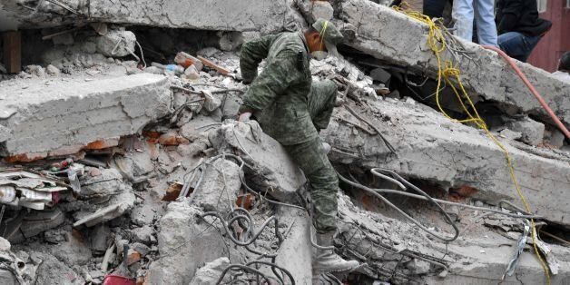 Rescuers, firefighters, policemen, soldiers and volunteers search for survivors in a flattened building in Mexico City on September 20, 2017 after a strong quake hit central Mexico on the eve killing at least 240 people.A powerful 7.1 earthquake shook Mexico City on Tuesday, causing panic among the megalopolis' 20 million inhabitants on the 32nd anniversary of a devastating 1985 quake. / AFP PHOTO / YURI CORTEZ (Photo credit should read YURI CORTEZ/AFP/Getty Images)
