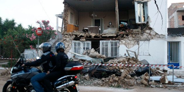 A motorcyclist rides past a destroyed house after a strong earthquake hit Kato Achaia village some 250Km west of Athens June 8, 2008. An earthquake measuring 6.5 on the Richter scale struck southern Greece on Sunday, killing two villagers, injuring another 50 people and damaging homes and a military base, authorities said. REUTERS/Yiorgos Karahalis (GREECE)
