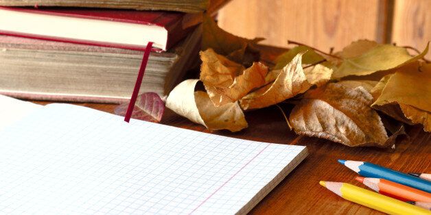 Composition with notebook, book and autumn leaves on wooden background. Autumn flat lay. Mock up for art work with workplace
