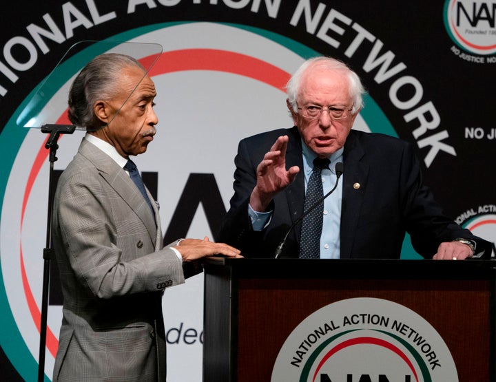 Bernie Sanders, right, speaks at a conference held by Rev. Al Sharpton in April. Sanders' critics say his efforts to focus more on race are too little, too late.