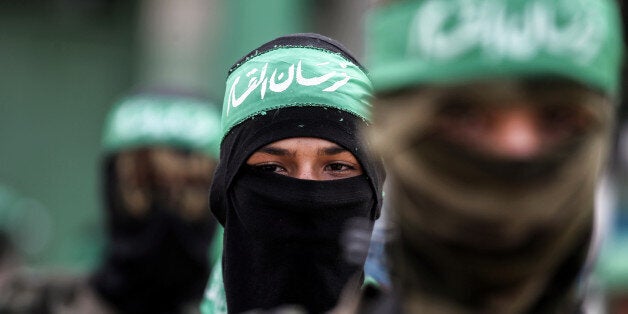 Masked youth cadets from the Ezzedine al-Qassam Brigades, the armed wing of the Palestinian Islamist Hamas movement, march in the southern Gaza Strip city of Khan Yunis on September 15, 2017. / AFP PHOTO / SAID KHATIB (Photo credit should read SAID KHATIB/AFP/Getty Images)