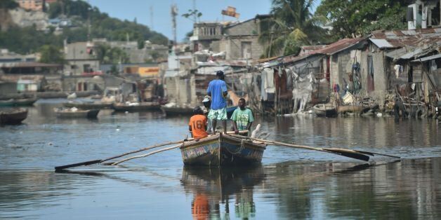 Men sail on Mapou Riverin Shadaa neighborhood, in Cap-Haitien, in the north of Haiti, 240 km from Port-au-Prince, ahead of Hurricane Irma on September 5, 2017.The monster hurricane coming on the heels of Harvey, which struck Texas and Louisiana late last month, is expected to hit a string of Caribbean islands including Guadeloupe late Tuesday before heading to Haiti and Florida. The Miami-based National Hurricane Center said Irma had strengthened to the most powerful Category Five, packing winds of 180 miles (280 kilometers) per hour. / AFP PHOTO / HECTOR RETAMAL (Photo credit should read HECTOR RETAMAL/AFP/Getty Images)