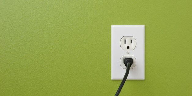 Electrical power outlet against a green painted wall.related: