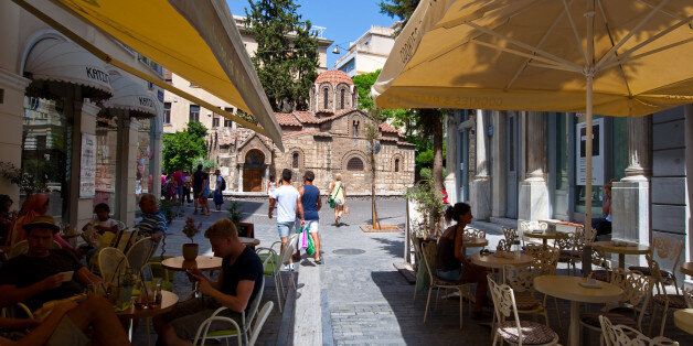 Athens, Greece - August 22, 2014: Traditional outside Greek cafe in Plaka area, customers enjoy their drinks.