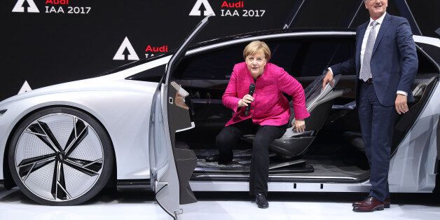 FRANKFURT AM MAIN, GERMANY - SEPTEMBER 14: German Chancellor Angela Merkel gets out of an Audi Aicon autonomous electric concept car as Rupert Stadler, Chairman of German carmaker Audi, looks on at the 2017 IAA Frankfurt Auto Show on September 14, 2017 in Frankfurt am Main, Germany. The Frankfurt Auto Show is taking place during a turbulent period for the auto industry. Leading companies have been rocked by the self-inflicted diesel emissions scandal. At the same time the industry is on the verge of a new era as automakers commit themselves more and more to a future that will one day be dominated by electric cars. (Photo by Sean Gallup/Getty Images)